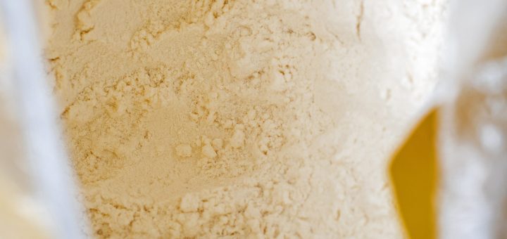 Close-up of pale flour powder inside a clear bag with yellow packaging accents.